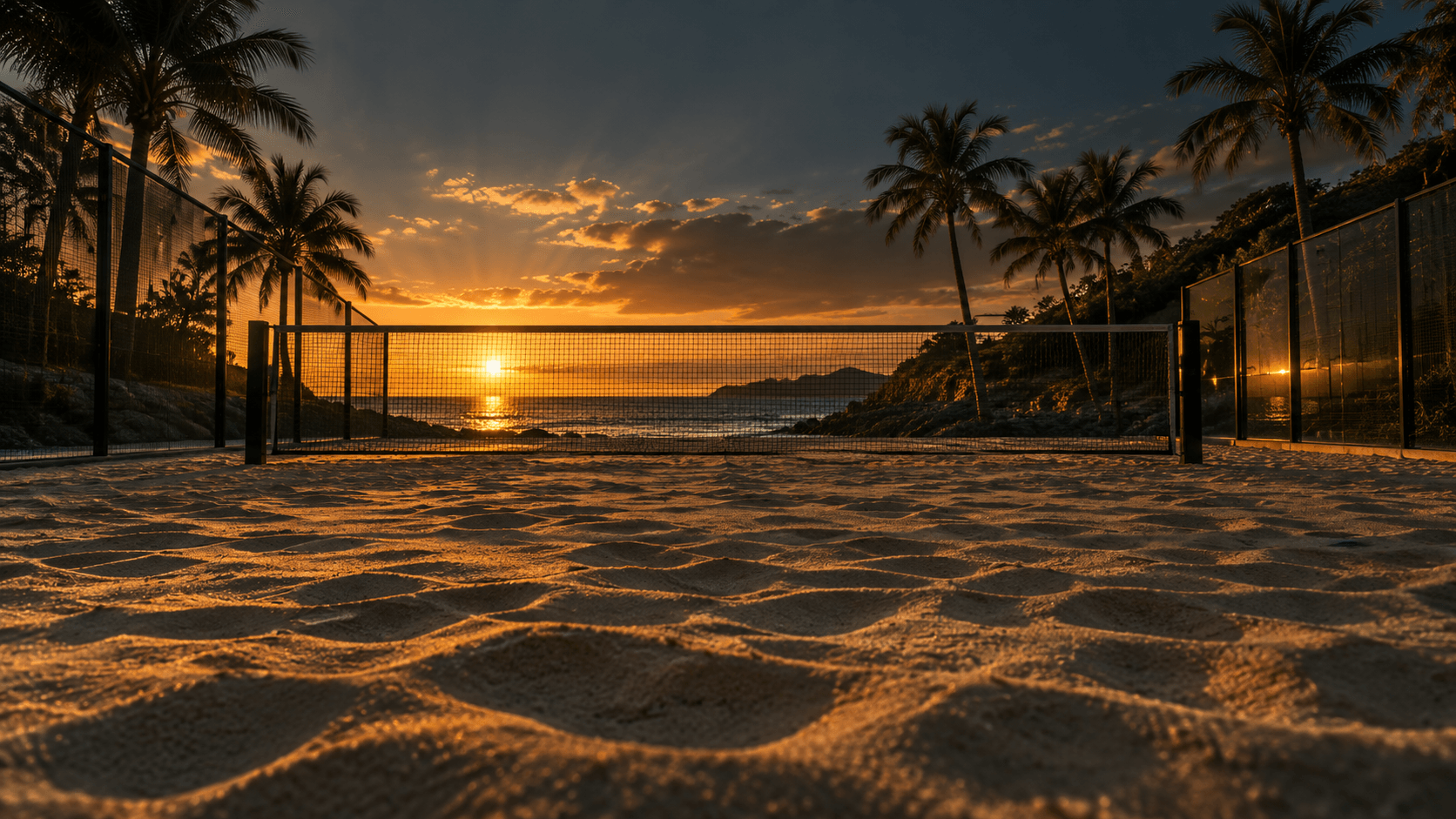 A beach padel court with sand and a net at sunset